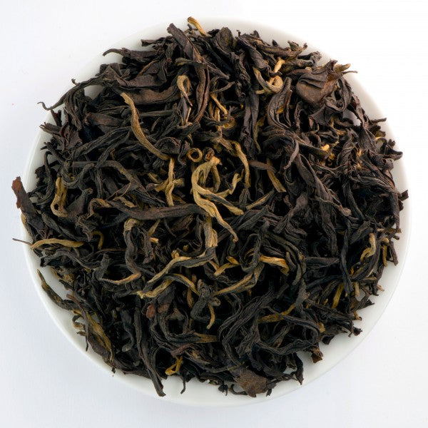 Organic Guangxi Gongfu black tea with twisted dark leaves, orange-golden tips, and a smooth, gently fruity character.