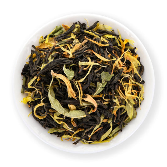 Assorted dried tea leaves in a white bowl on a white background