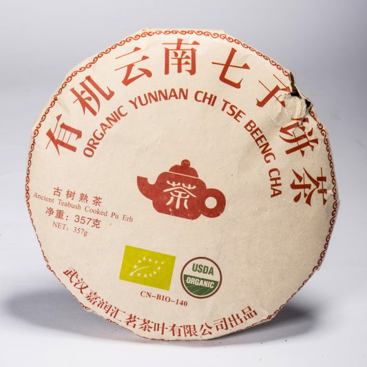 Organic Yunnan cooked Pu-Erh Beeng Cha tea cake in traditional paper wrapping, 357 g.