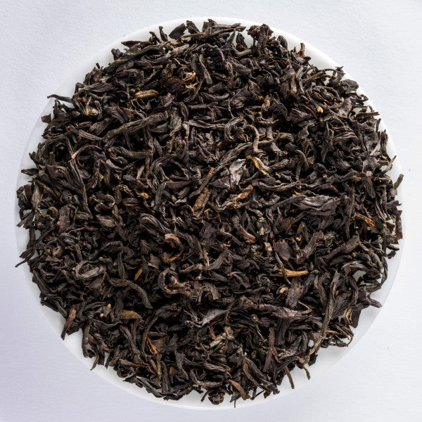 Tarry Lapsang Souchong loose-leaf smoked black tea with dark twisted leaves and an intense wood-smoke aroma by Lunula Tea.