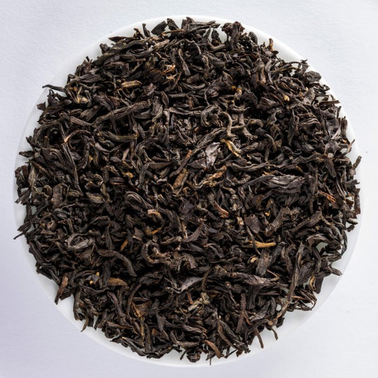 Tarry Lapsang Souchong loose-leaf smoked black tea with dark twisted leaves and an intense wood-smoke aroma by Lunula Tea.